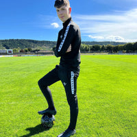 Bas d'entraînement Aways Performer noir porté - sur terrain de football avec ballon