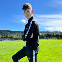 Haut d’entraînement Aways Performer noir porté – vue de profil sur terrain de football