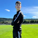 Haut d’entraînement Aways Performer noir porté – détail bandes latérales