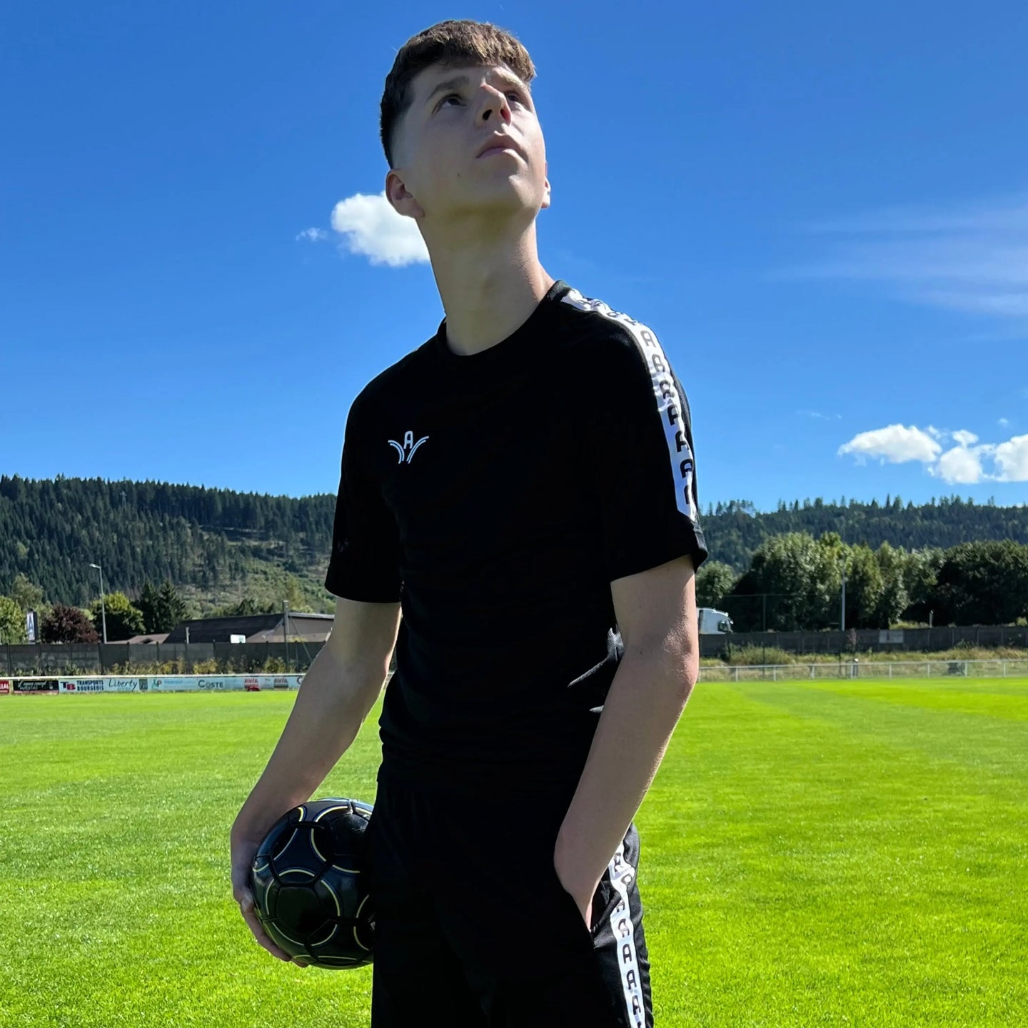 Maillot d'entraînement Aways Performer noir porté - vue de profil avec ballon de football