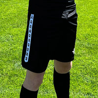 Short d'entraînement Aways Performer noir porté - détail bande latérale et logo