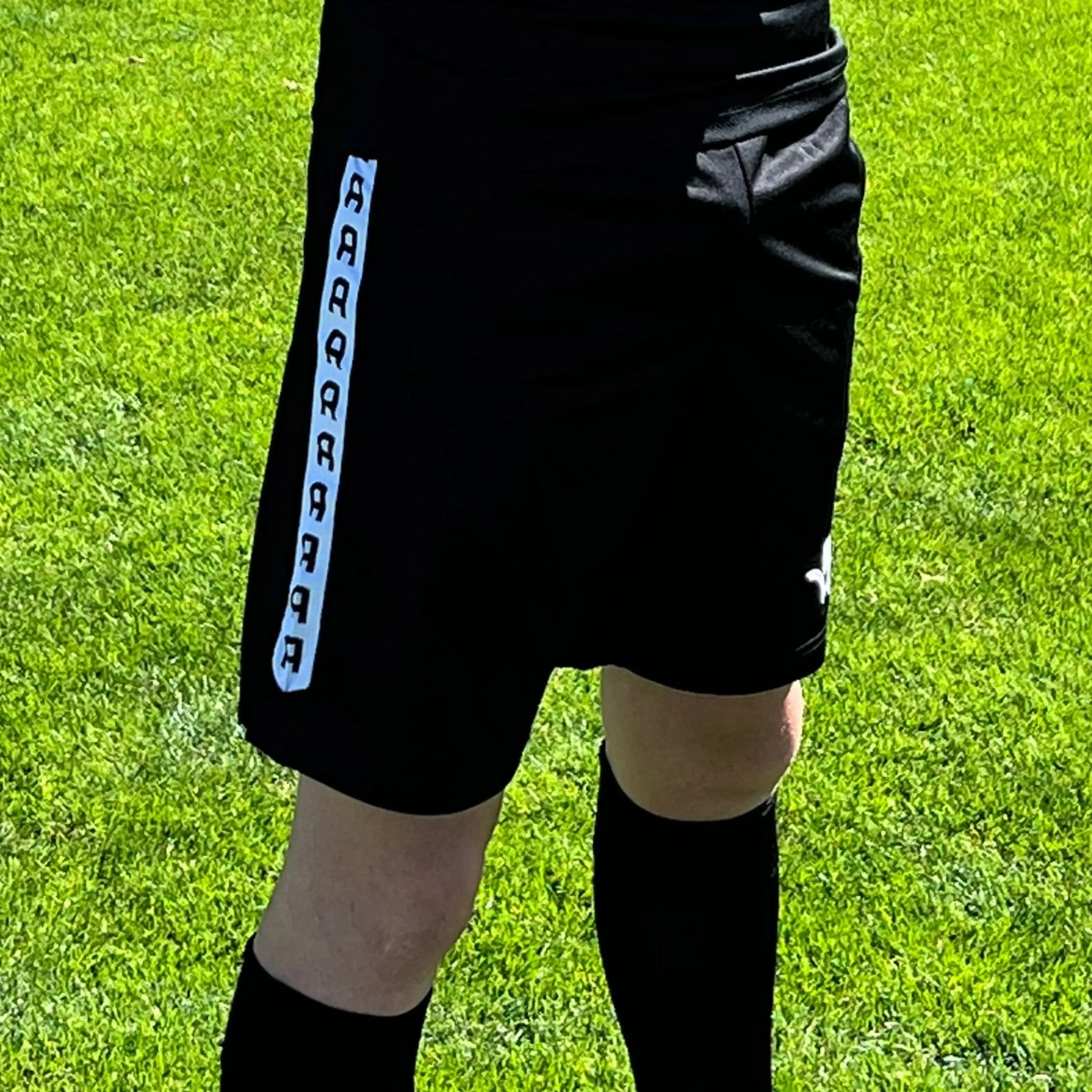 Short d'entraînement Aways Performer noir porté - détail bande latérale et logo